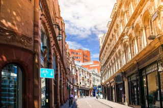 Decorative image: a photo of a winding shopping street in the sunshine