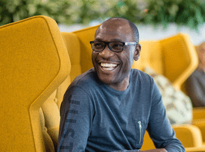 Man smiling in a big comfortable yellow chair
