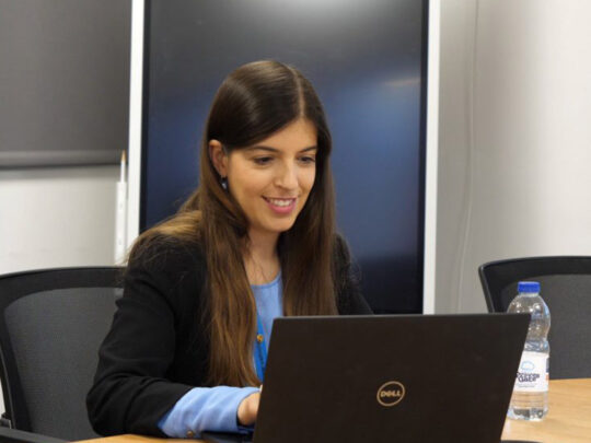 VCA staff member in a meeting, looking down at her laptop.