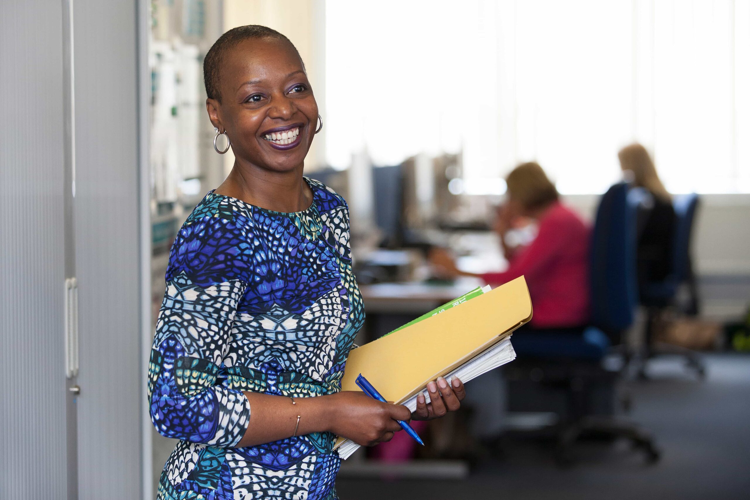 woman smiling holding files