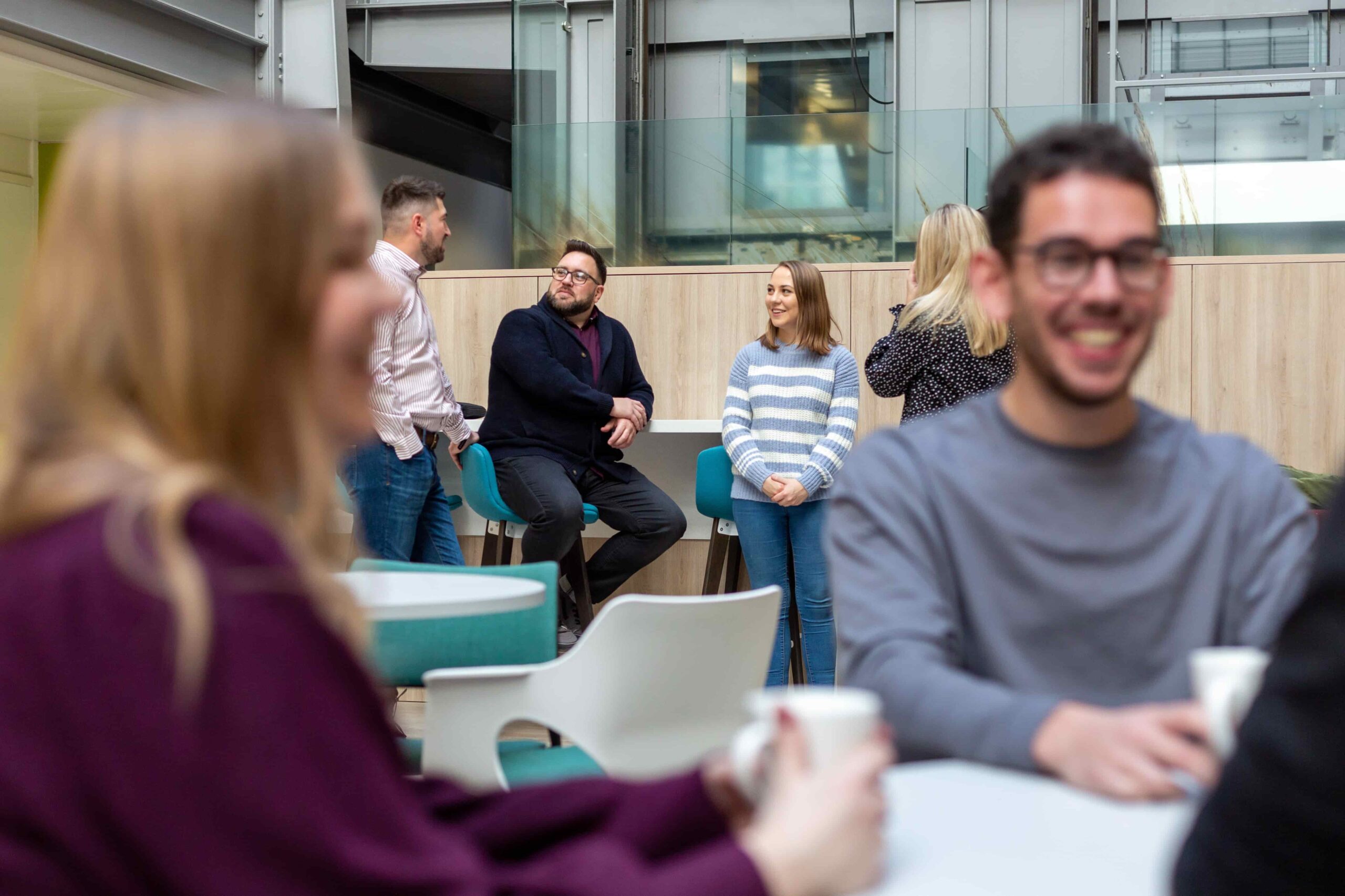 Group of colleagues in an office space smiling and chatting