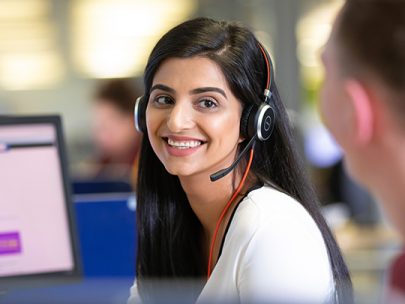 Female HMRC Employee In A Customer Contact Centre Using A Headset