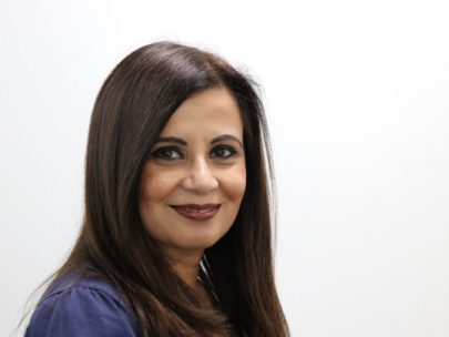 A Portrait Of Anita Jain, she has long dark hair and is smiling softly