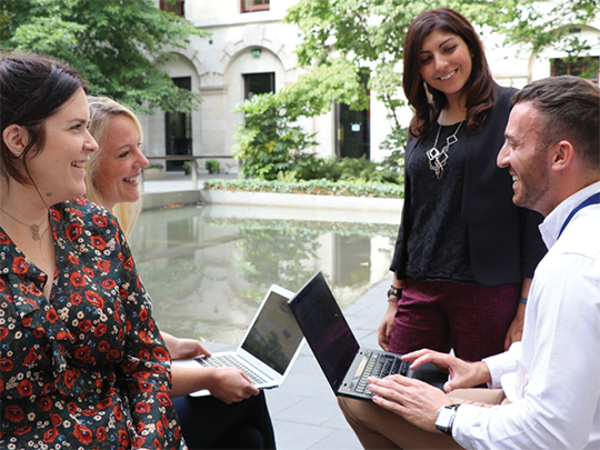 A group of Civil Servants sitting outside in the garden at 100 Parliament Street