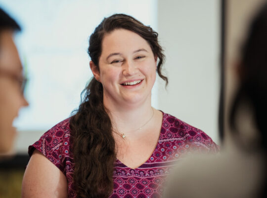 Female Colleague Smiling At Two Colleages