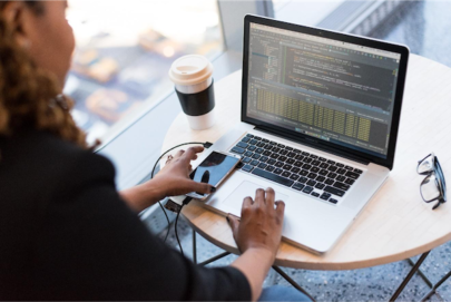 person working at a table on a laptop with a coffee