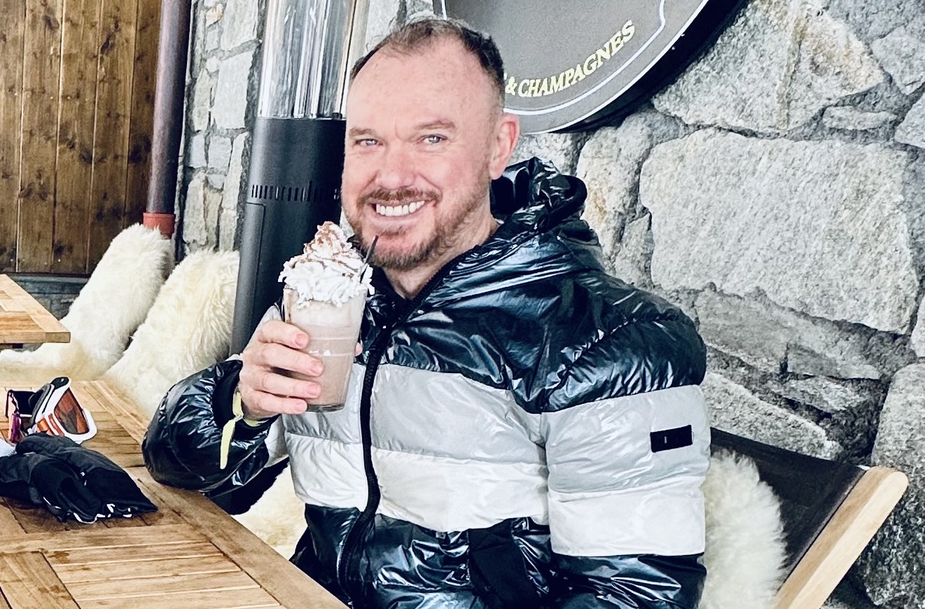 Image of Lyle Pewsey wearing a large coat and holding a chocolate milkshake