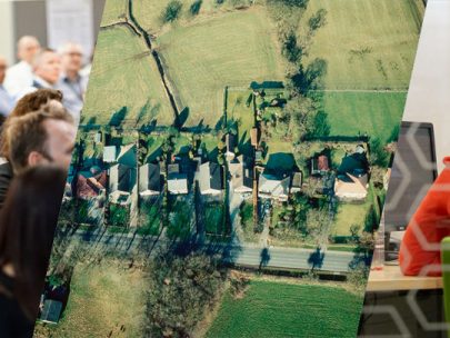Collage showing an aerial view of houses in the countryside, and civil servants in a room listening to a presenter