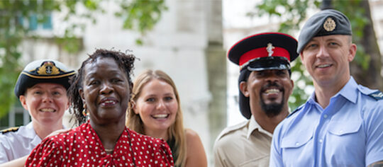 A photo of representatives from the armed forces, next to a grave.