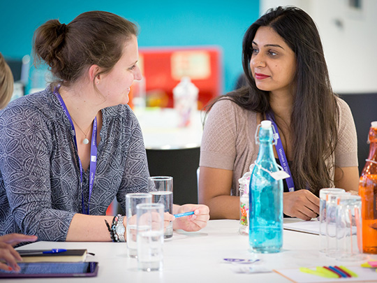 Two HMRC Team Members in Conversation at Table