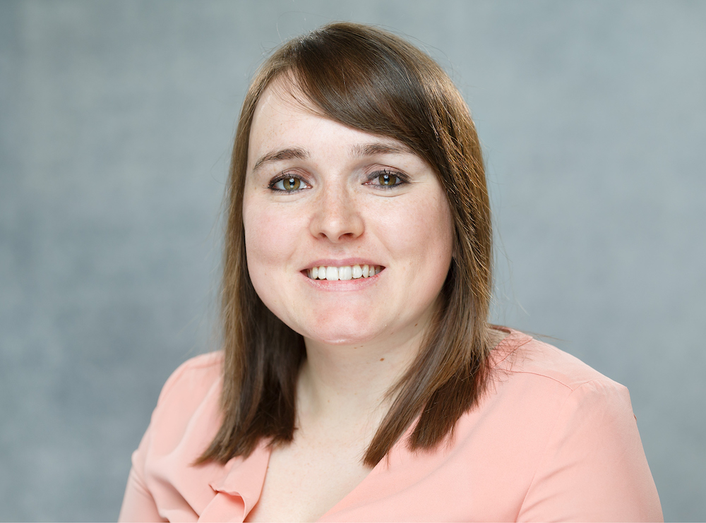 A photo of Rebecca. She is wearing a peach coloured top and has brown hair.