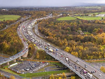 An aerial photo of a busy road winding through picturesque countryside