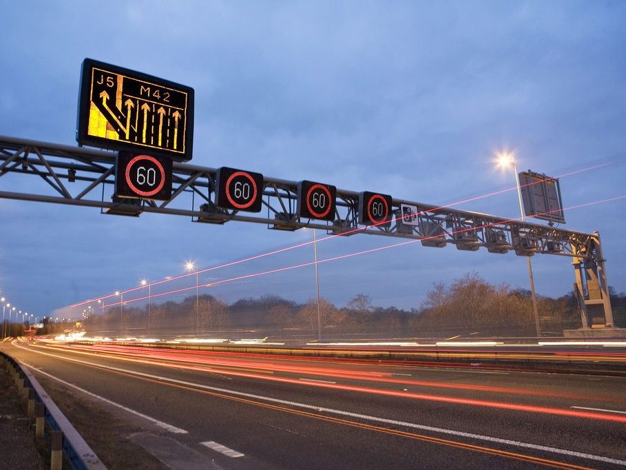 A photo of a motorway gantry with lit signs over each lane