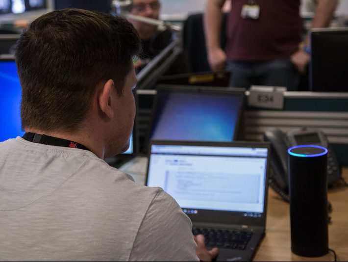 A DVLA employee working on their laptop in a shared space