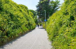 View of a pedestrian and bicycle path between grassy embankments