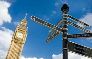 A photo of a Whitehall Tourist Sign, giving directions to points of interest, with the tower of Big Ben in the background