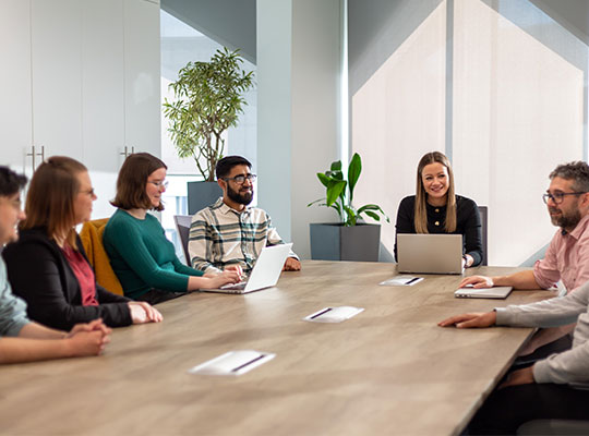 Group of colleagues sat around a big table