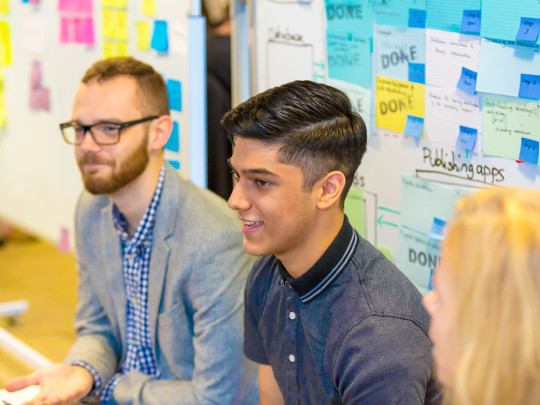 Three Civil Servants Sitting In Front Of Whiteboard