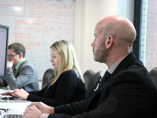 Three Counter Fraud Team Members working at their desks, looking focused