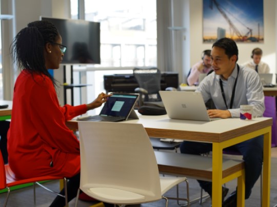 Two Team Members At Homes England working at a table together