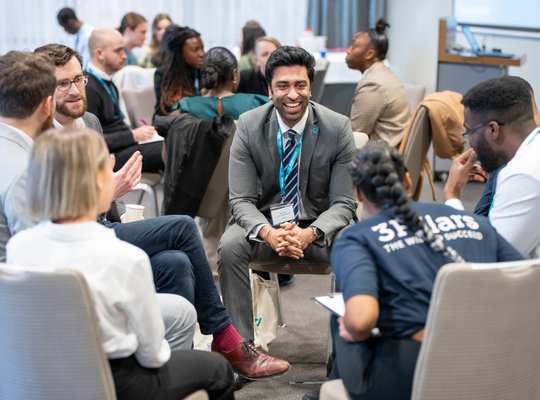 colleagues smiling and chatting in small groups