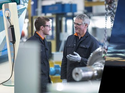 A photo of Two Engineers In Discussion in a robotics workshop