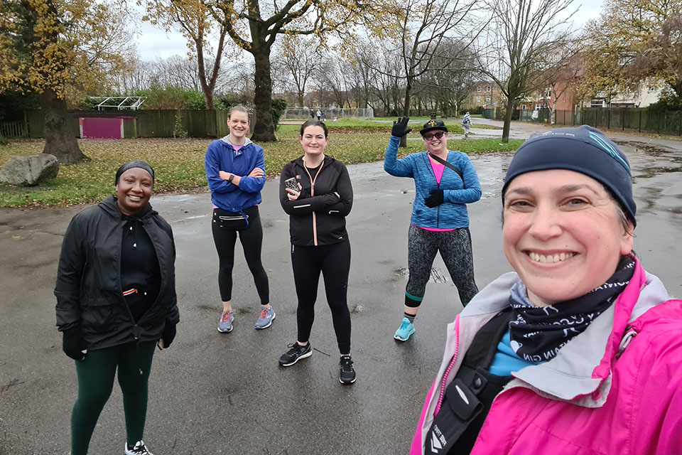 A photo of a group of people outside in sportswear on a cloudy day. They look happy and excited.