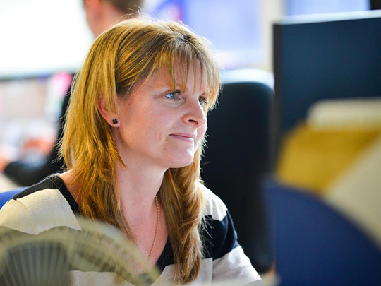 Woman In Striped Jumper Working At Desk