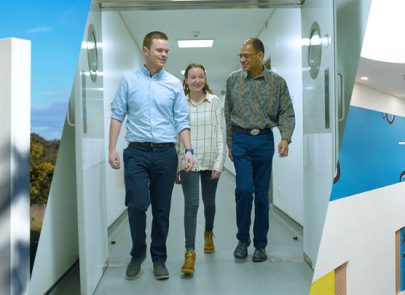 Three DSTL employees walking down a corridor in conversation