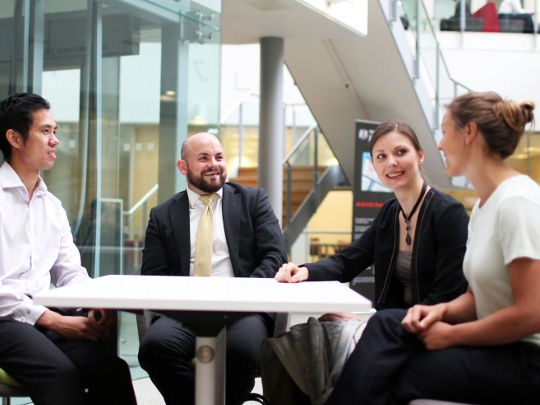 Four Analysis Team Members At a Table, in discussion