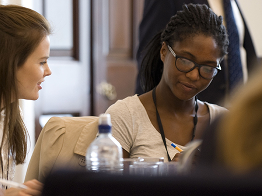 Two Government Communication Team Members at a Conference, chatting together